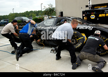 Boxencrew in Motion blur im Reifen Änderung Training auf einem NASCAR-Rennwagen bei Michael Waltrip Raceworld USA Stockfoto