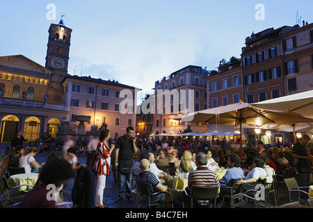 Gäste in einem Straßencafé Santa Maria in Trastevere Kirche im Hintergrund Rom Italien Stockfoto