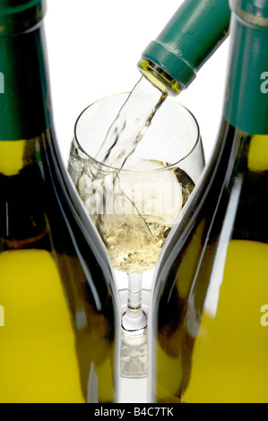 Still-Leben. Gießen ein Glas französischen Wein mit Flaschen im Vordergrund weißen chardonay Stockfoto