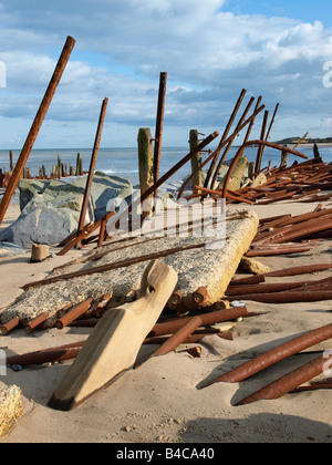 Meer Abwehr gebogen und durch Wellengang verdreht. Durch die Felsen am happisburgh Norfolk England geschützt Stockfoto