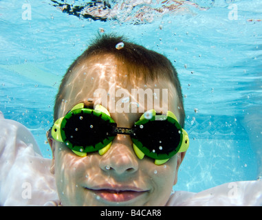 Diese sieben Jahre alter Junge zeigt wird unter Wasser schwimmen Fähigkeiten mit einem großen Lächeln neu erworben. Stockfoto