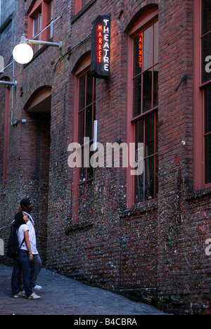 Ein paar untersucht die Gum-Wand in Seattle Post Gasse am Pike Place Market. Stockfoto