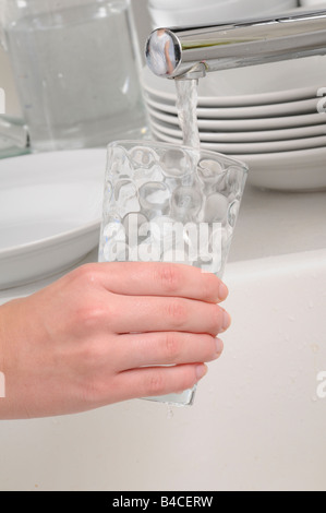 FRAU GLAS TUMBLER MIT LEITUNGSWASSER FÜLLEN Stockfoto