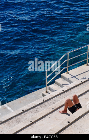 Mann Sonnenbaden direkt am Meer in Monaco. Bild von Patrick Steel patricksteel Stockfoto