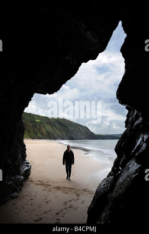 EINE FIGUR IN EINER HÖHLE AM STRAND VON PENBRYN CEREDIGION WEST WALES UK Stockfoto