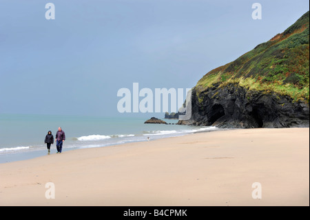 EIN PAAR FUß IHREN HUND AM STRAND VON PENBRYN CEREDIGION WEST WALES UK Stockfoto