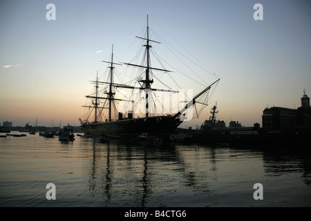 Stadt von Portsmouth, England. Silhouette Abenddämmerung Blick auf HMS Warrior bei Portsmouth Historic Dockyard festgemacht. Stockfoto