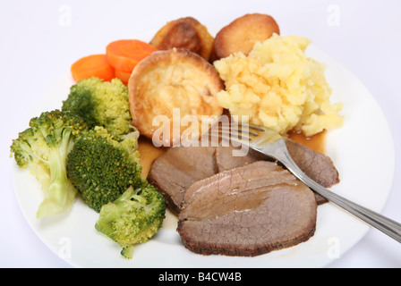 Ein Abendessen mit Scheiben von geschmorter Topf gebraten Rindfleisch Brokkoli Karotten Kartoffelpüree, Kartoffel braten Kartoffel englischen Yorkshire Puddings und gravy Stockfoto