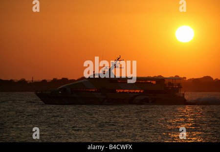 Stadt von Portsmouth, England. Blick auf den Sonnenuntergang von der schnell Cat Ferry Transit von Portsmouth Harbour zur Isle Of Wight Silhouette. Stockfoto