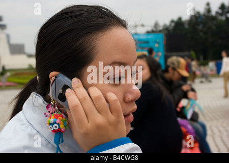 Taiwanesische chinesische junge Frau am zellularen Mobilfunk Stockfoto