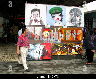 Ein Mann geht vorbei an Kunst zum Verkauf Panjiayuan Flohmarkt in Bejing, China Stockfoto