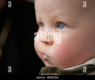 Baby Boy mit blauen Augen und Milch im Mund Stockfoto