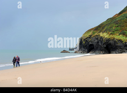 EIN PAAR FUß IHREN HUND AM STRAND VON PENBRYN CEREDIGION WEST WALES UK Stockfoto