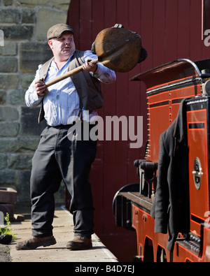 Stoker Ausfüllen einer Dampfmaschine zart mit Kohle an die Beamish Open Air Museum in County Durham, England Stockfoto
