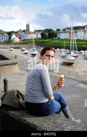 JUNGE FRAU EIN EIS AM HAFEN BEI ABERAERON CARDIGAN BAY CEREDIGION WEST WALES UK Stockfoto