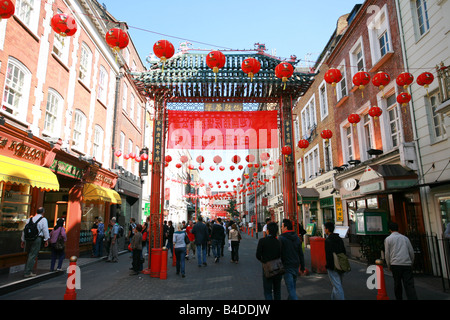 Touristen gehen unter rote Haupttor Eingang zu China Town im Londoner West End England UK Stockfoto