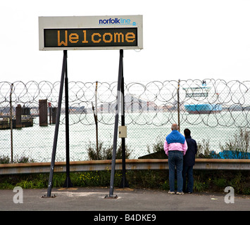 Menschen stehen hinter Sicherheitszaun mit Willkommensschild Fähre terminal Dünkirchen France Stockfoto