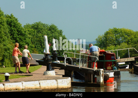 Boot, Verhandlungen über den Flug der Schleusen von Hatton Warwickshire mit St Mary s Stiftskirche Warwick in der Ferne Stockfoto
