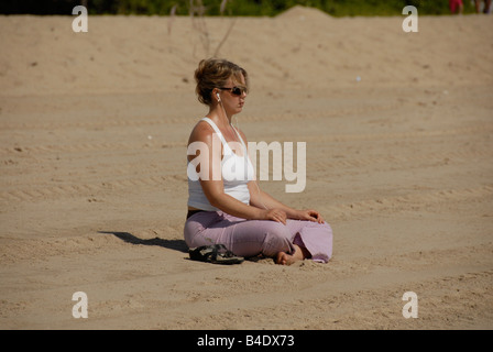 Junge Frau praktizieren Yoga am Strand. Stockfoto