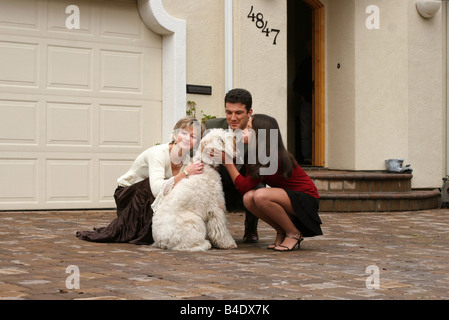 Glückliche Familie mit einem Hund vor dem Haus Stockfoto