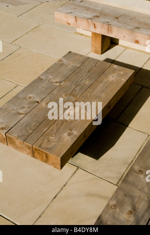 hölzerne Bestuhlung im modernen gepflasterten Garten Stockfoto