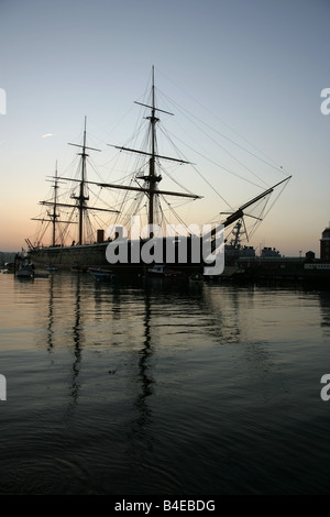 Stadt von Portsmouth, England. Silhouette Abenddämmerung Blick auf HMS Warrior bei Portsmouth Historic Dockyard festgemacht. Stockfoto
