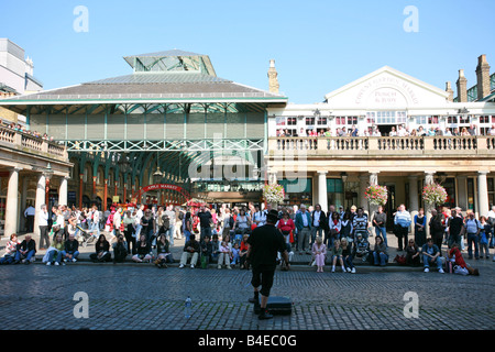 Straßenkünstler spielt eine große Menge von Touristen montiert Covent Garten, sehr beliebte Sightseeing in London UK Stockfoto