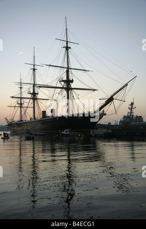 Stadt von Portsmouth, England. Silhouette Abenddämmerung Blick auf HMS Warrior bei Portsmouth Historic Dockyard festgemacht. Stockfoto