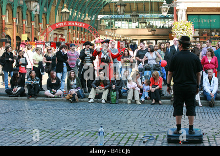 Straßenkünstler spielt eine große Menge von Touristen montiert Covent Garten, sehr beliebte Sightseeing in London UK Stockfoto