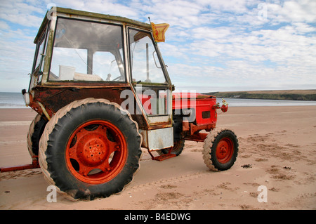 Ein Alter Traktor für kleine Boote Abschleppen und Fanggeräte verwendet wird am Strand von Lunan Bay in Angus geparkt. Stockfoto