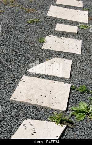 Hellen Trittsteine auf grauem Kies im Garten Stockfoto