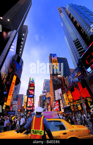 Ein Verkehrspolizist leitet ein vorbeifahrendes Taxi Taxi in einer geschäftigen Zeiten Squre New York Stadt voller Touristen Stockfoto