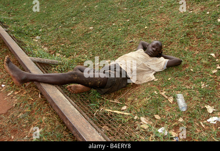 Obdachlose junge ausgestreckt auf den Boden ablassen, den Schlaf, die Auswirkungen von Klebstoff - schnüffeln. Kampala, Uganda. Stockfoto