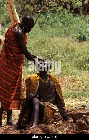 Ethnische Karamojong Mann das Gesicht rasieren, Karamoja, Uganda Stockfoto