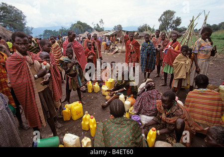 Ethnische Karamojong Dorfbewohner warten mit Benzinkanister in Dorf, Karamoja, Uganda Stockfoto