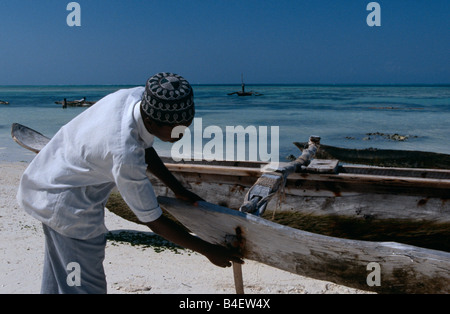 Lokale muslimische Fischer und seine Boot am Strand. Sansibar. Stockfoto