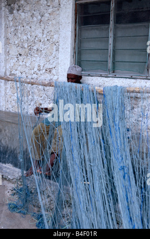 Mann ein Fischernetz in Südafrika zu reparieren. Stockfoto