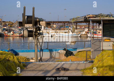 Gelbe Fischernetzen und Winde Hebezeuge mit Küstenfischerei Boote festgemacht in Lavrion Hafen griechische Festland Ägäis Griechenland Stockfoto