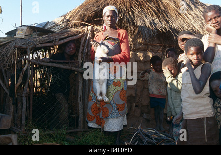 Kaninchen Landwirt mit weißen Kaninchen, von Kindern umgeben, Angola Stockfoto