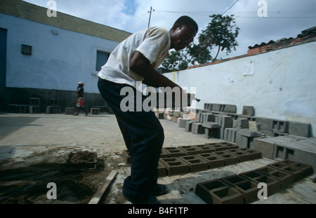 Arbeitnehmer Ziegel Festlegung auf Erde in Baustelle, Angola Stockfoto