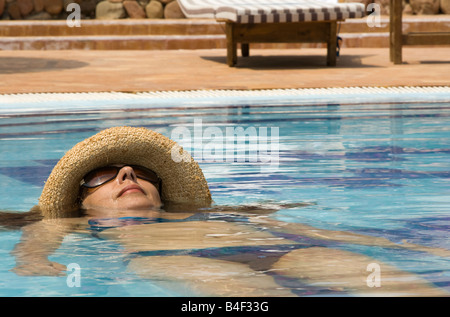Junge Frau im Schwimmbad tragen Stroh Hut Stockfoto