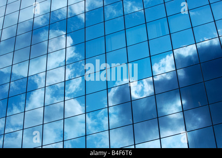 Wolken spiegeln sich in den gespiegelten Fenstern eines Gebäudes der Stadt Stockfoto