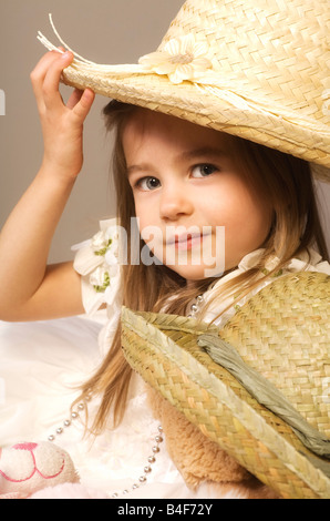 Mädchen und Teddybär tragen Strohhüte Stockfoto