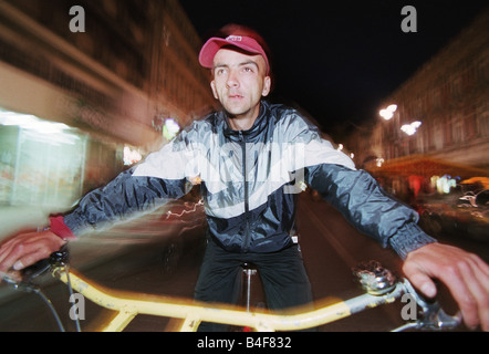 Porträt von einem Rikscha-Fahrer während der Fahrt durch die Piotrkowska-Straße in Lodz, Polen Stockfoto