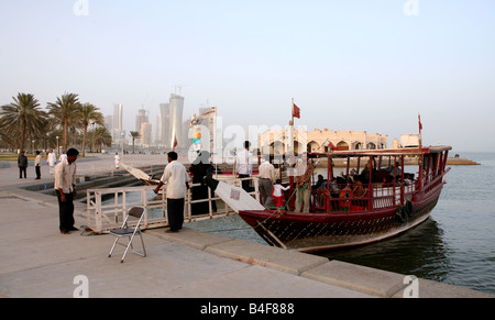 Einsteigen in ein Vergnügen Dhau festgemacht an der Corniche in Doha Katar Familien bieten die kleinen Boote Vergnügungsreisen rund um die Bucht Stockfoto