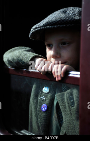 Kleiner Junge gekleidet in Tweed und flache Kappe aus Eisenbahn Wagen Fenster Stockfoto