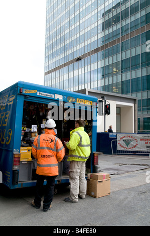 Östliche europäische Migranten Bauarbeiter Kauf arbeiten Gang von ambulanten Händler in Canary Wharf, London Foto Julio Etchart Stockfoto