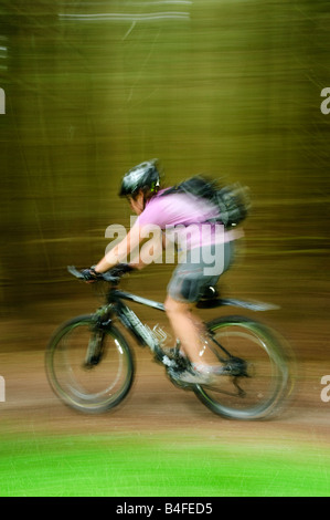 Weibliche Mountainbiker mit Geschwindigkeit im Gisburnund Wald in der Bowland Fells Lancashire Stockfoto