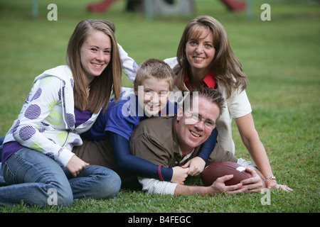 Glückliche Familie mit einem Sohn und einer Tochter Vater und Mutter auf der Rückseite Hof zu Hause mit dem Fußball Stockfoto