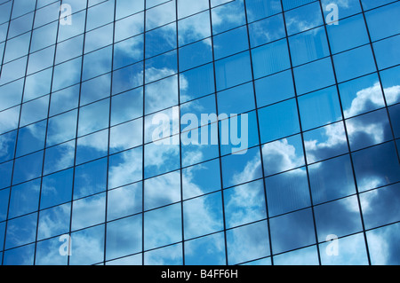 Wolken spiegeln sich in den gespiegelten Fenstern eines Gebäudes der Stadt Stockfoto